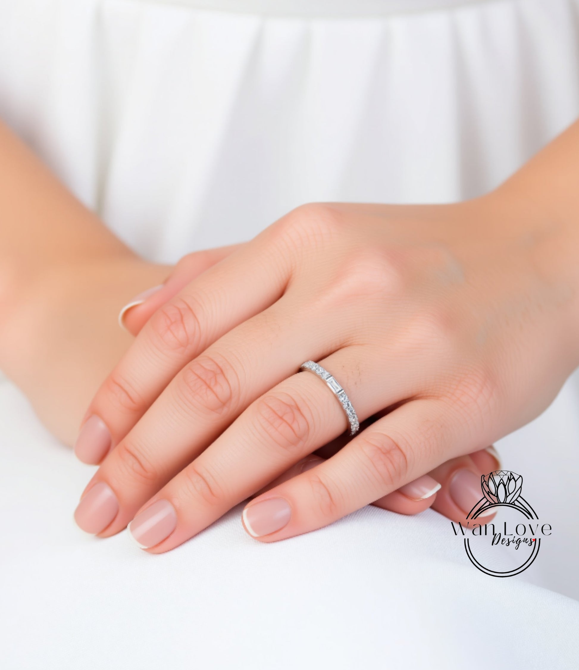 A close-up of a person's hand wearing a diamond ring on the ring finger.