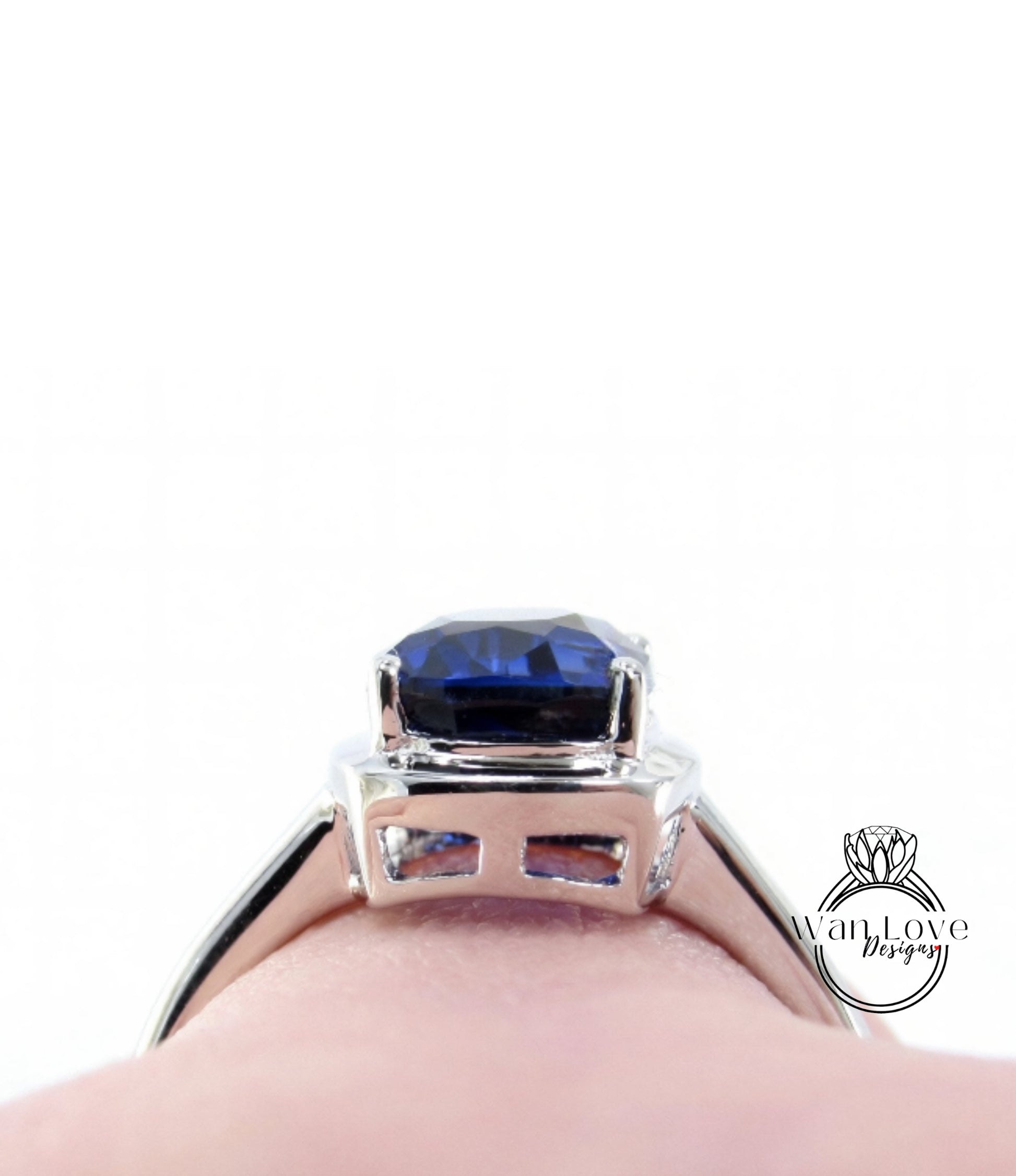 A close-up view of a silver ring with a large blue gemstone, likely a sapphire, set in the center.
