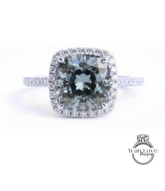 A large, square-cut diamond ring with a halo of smaller diamonds around the center stone.