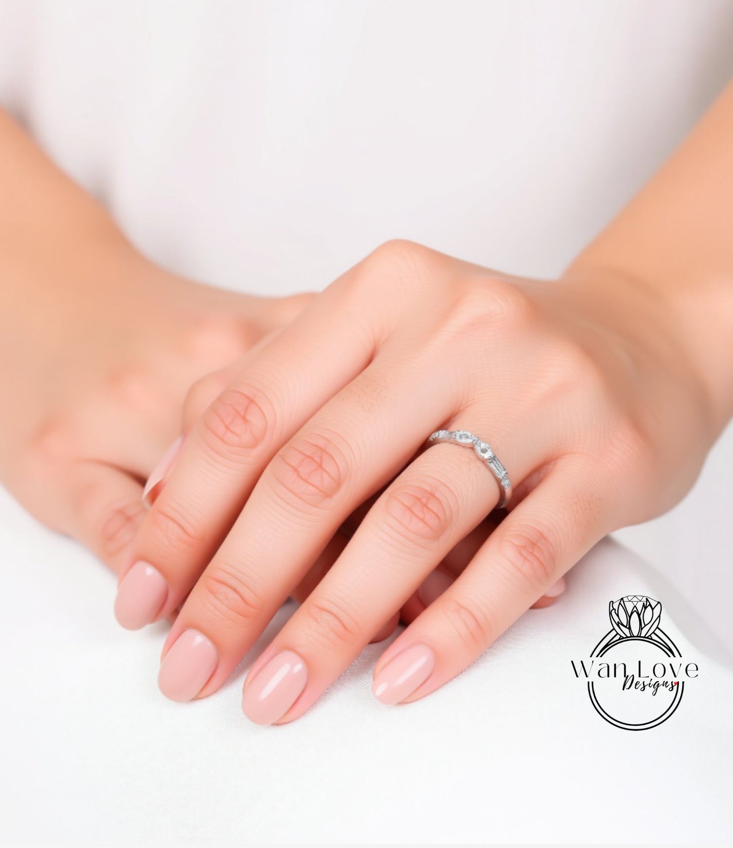 A close-up image of a person's hands wearing a ring on the ring finger.