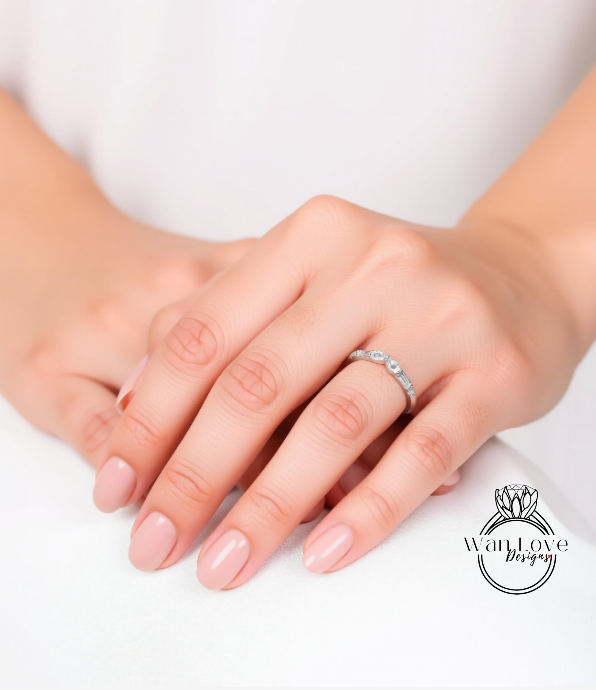 A close-up image of a person's hands wearing a ring on the ring finger.