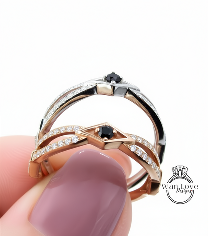 A close-up of a person's hand holding a ring with two diamond-encrusted bands and a black gemstone.
