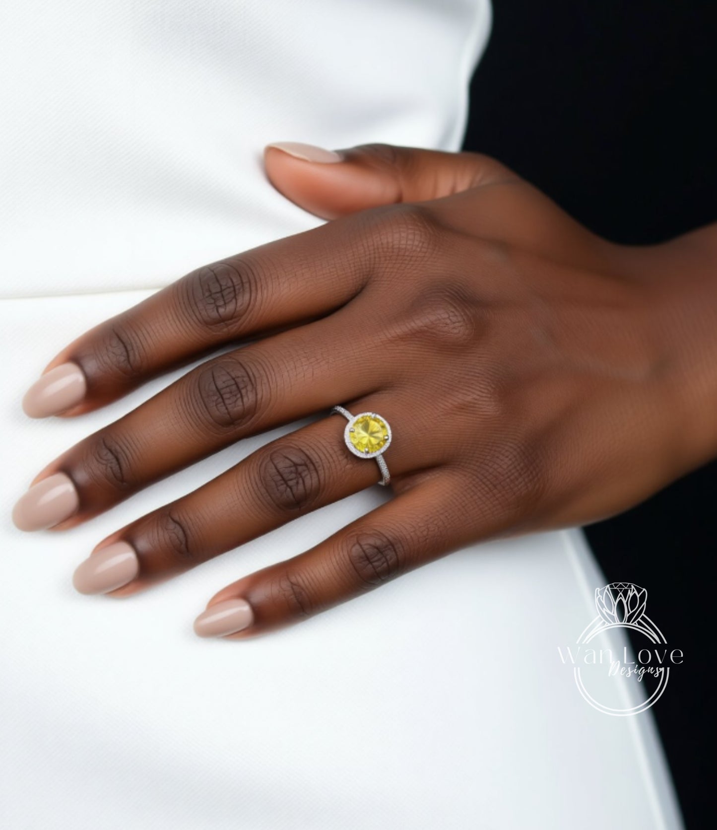A close-up of a hand wearing a ring with a yellow gemstone.
