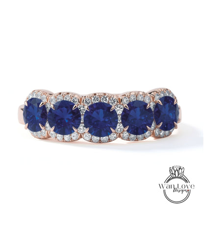 A ring with a row of blue sapphire gemstones set in a rose gold band.