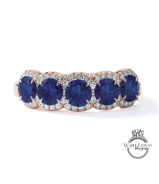 A ring with a row of blue sapphire gemstones set in a rose gold band.