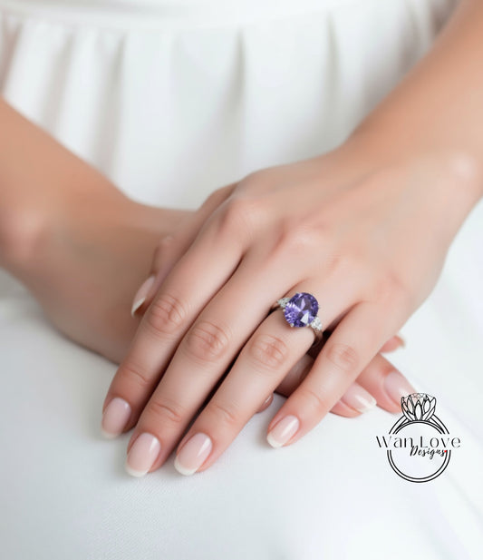 A close-up of a person's hand wearing a ring with a large purple gemstone.