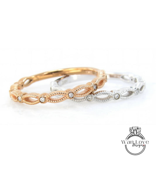 A close-up image of two rings with intricate designs and small diamonds set in them.