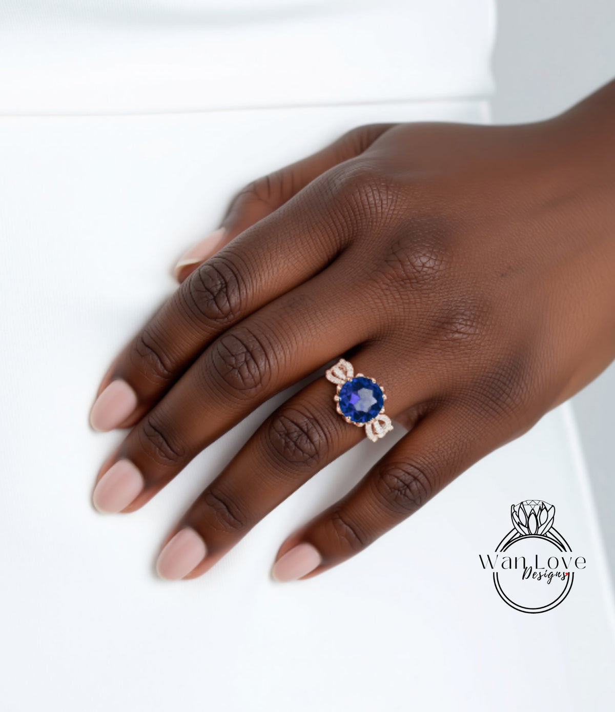 A close-up of a hand wearing a ring with a large blue gemstone.