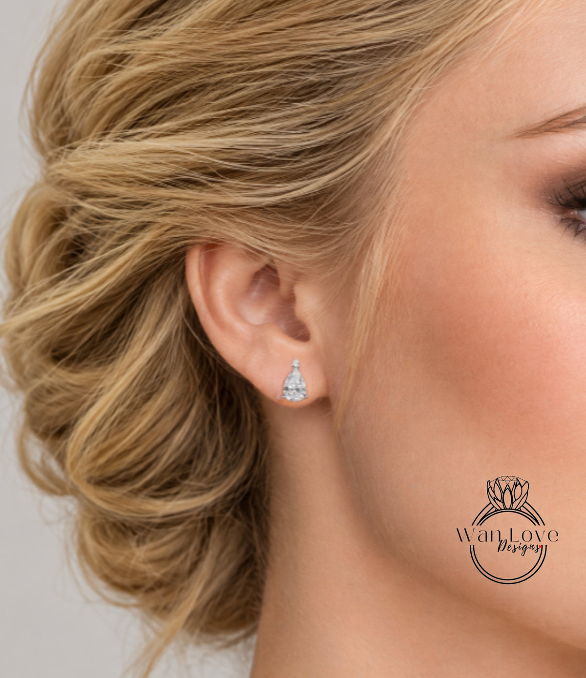A close-up of a woman's ear with a diamond earring, showcasing the earring and the woman's face.