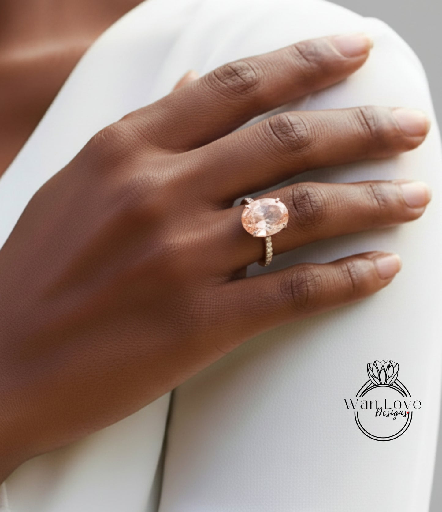 A close-up of a hand wearing a large, round, pink gemstone ring on the ring finger.