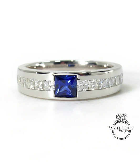 A silver ring with a large blue gemstone in the center, surrounded by smaller diamonds.