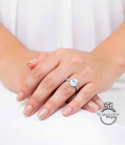 A close-up of a person's hands wearing a large diamond engagement ring.