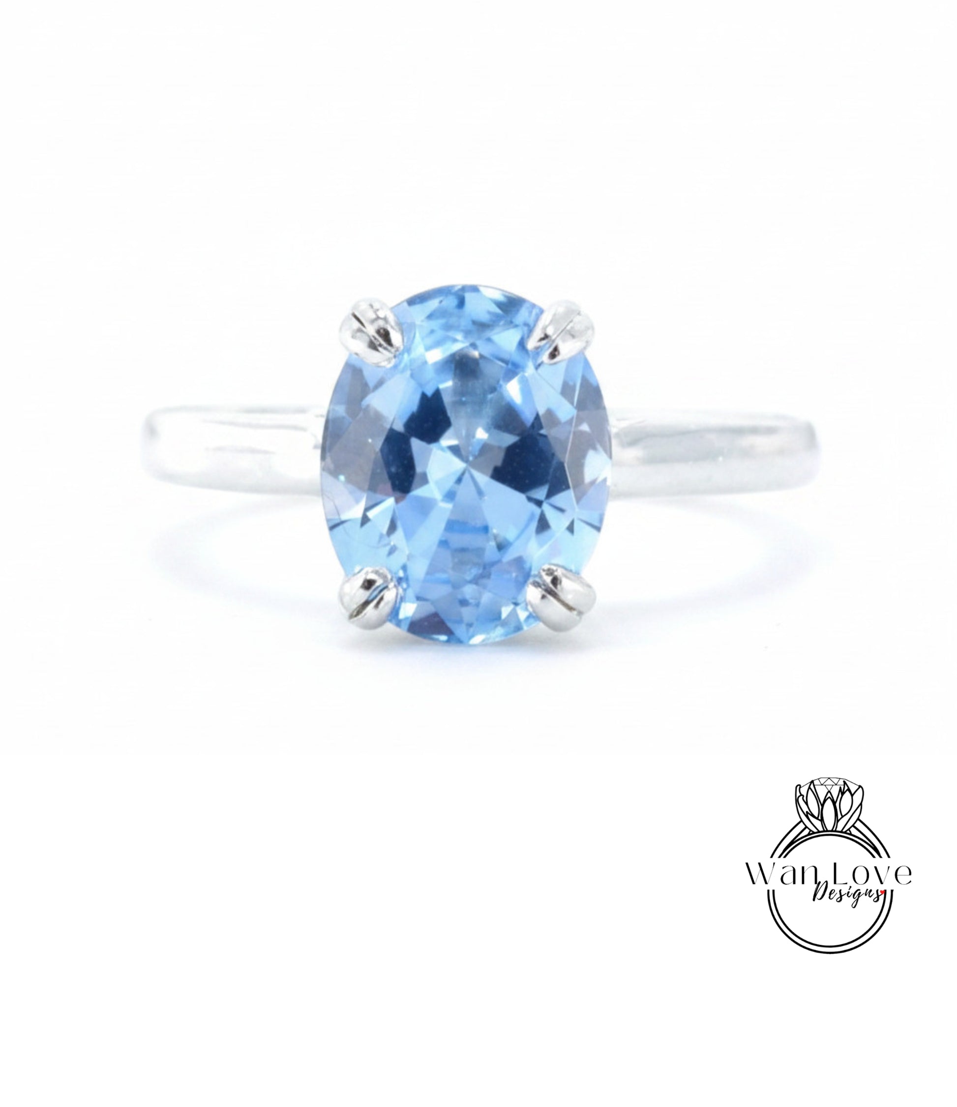 A close-up image of a silver ring with a large, blue gemstone set in the center.