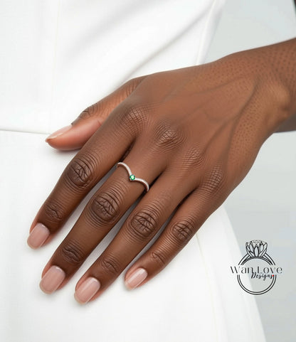 A close-up of a hand wearing a ring with a green gemstone.
