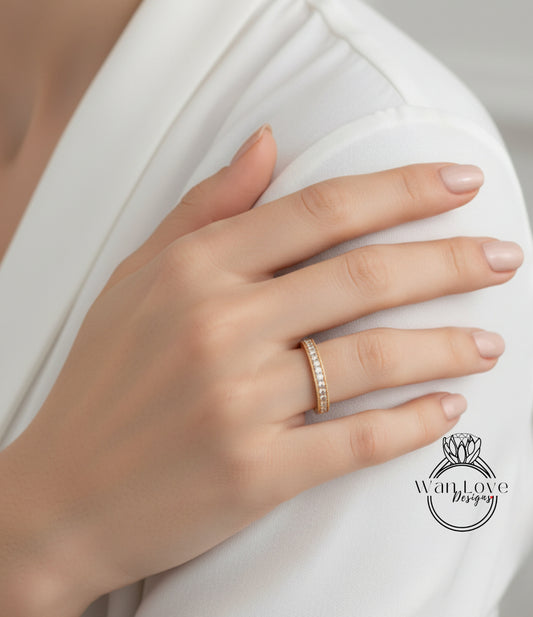 A close-up of a person's hand wearing a gold ring on the ring finger.