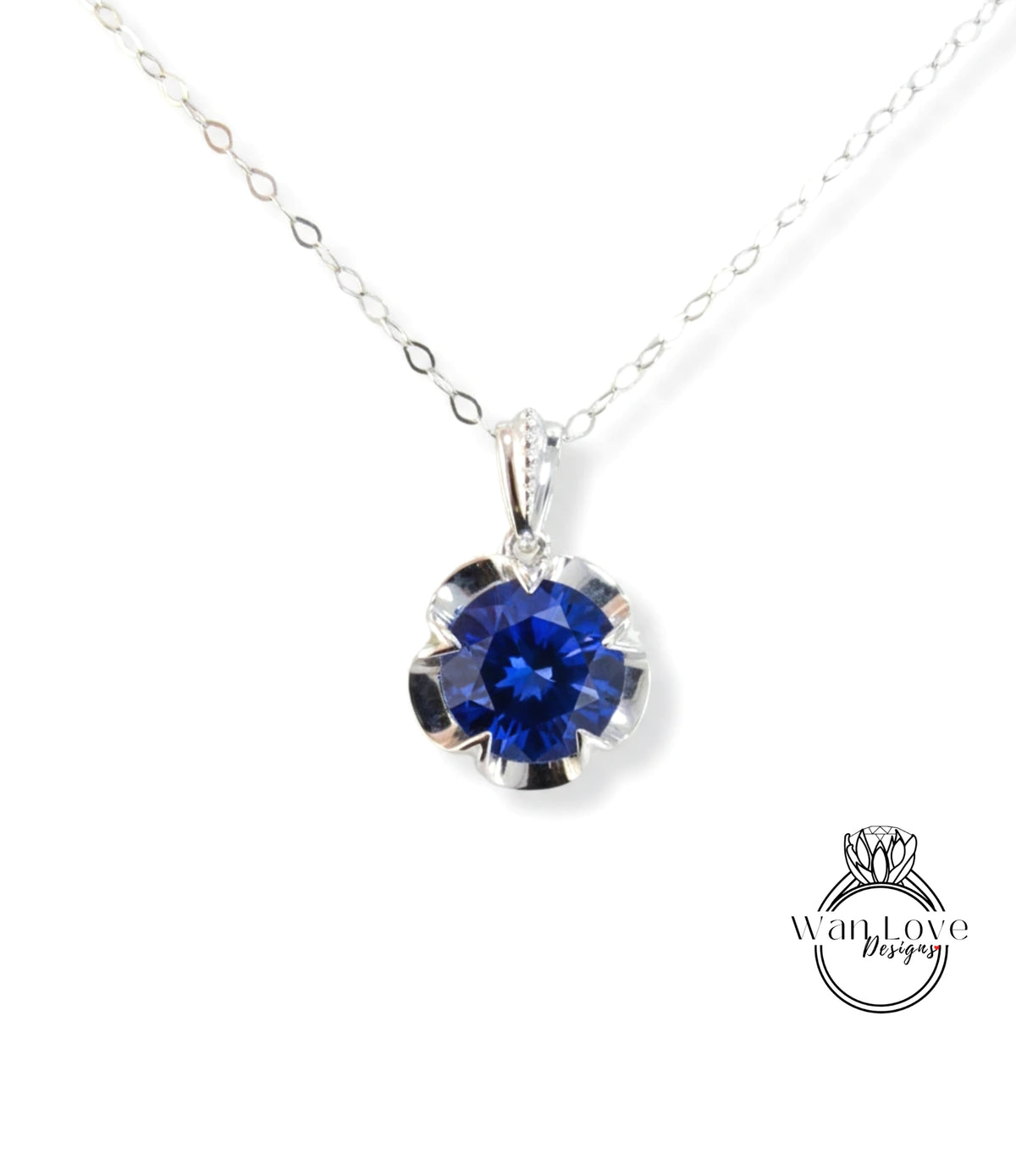A silver necklace with a large blue gemstone pendant.