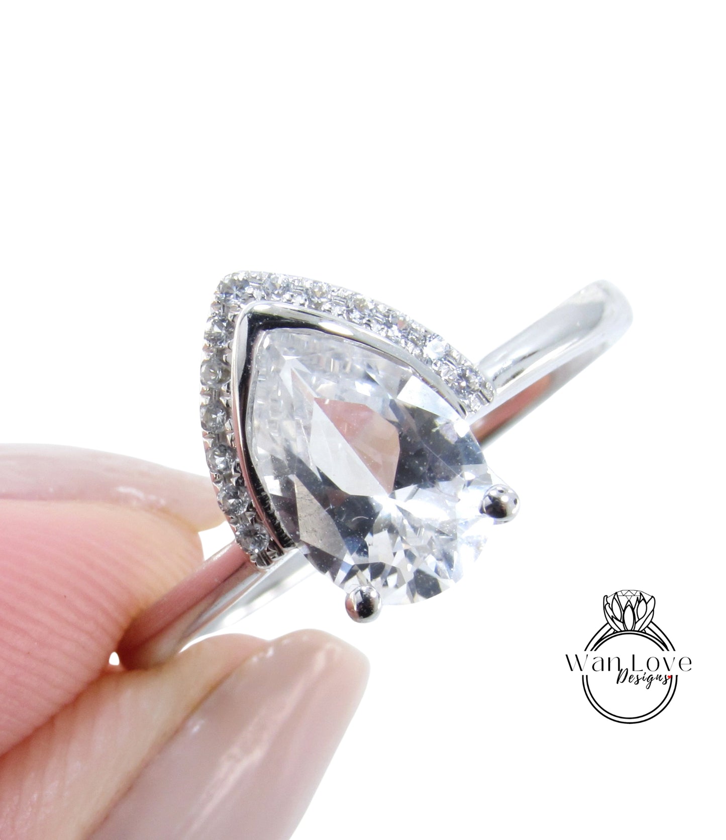 A close-up image of a person's hand holding a diamond ring with a large, clear gemstone.