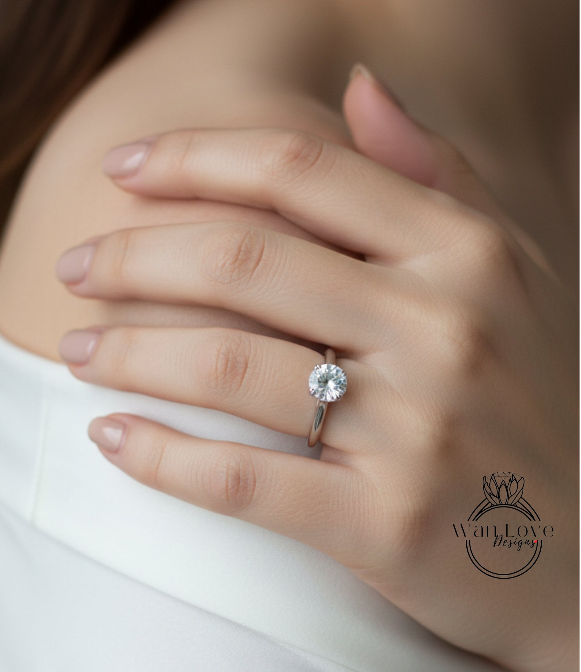 A close-up of a person's hand wearing a diamond engagement ring.