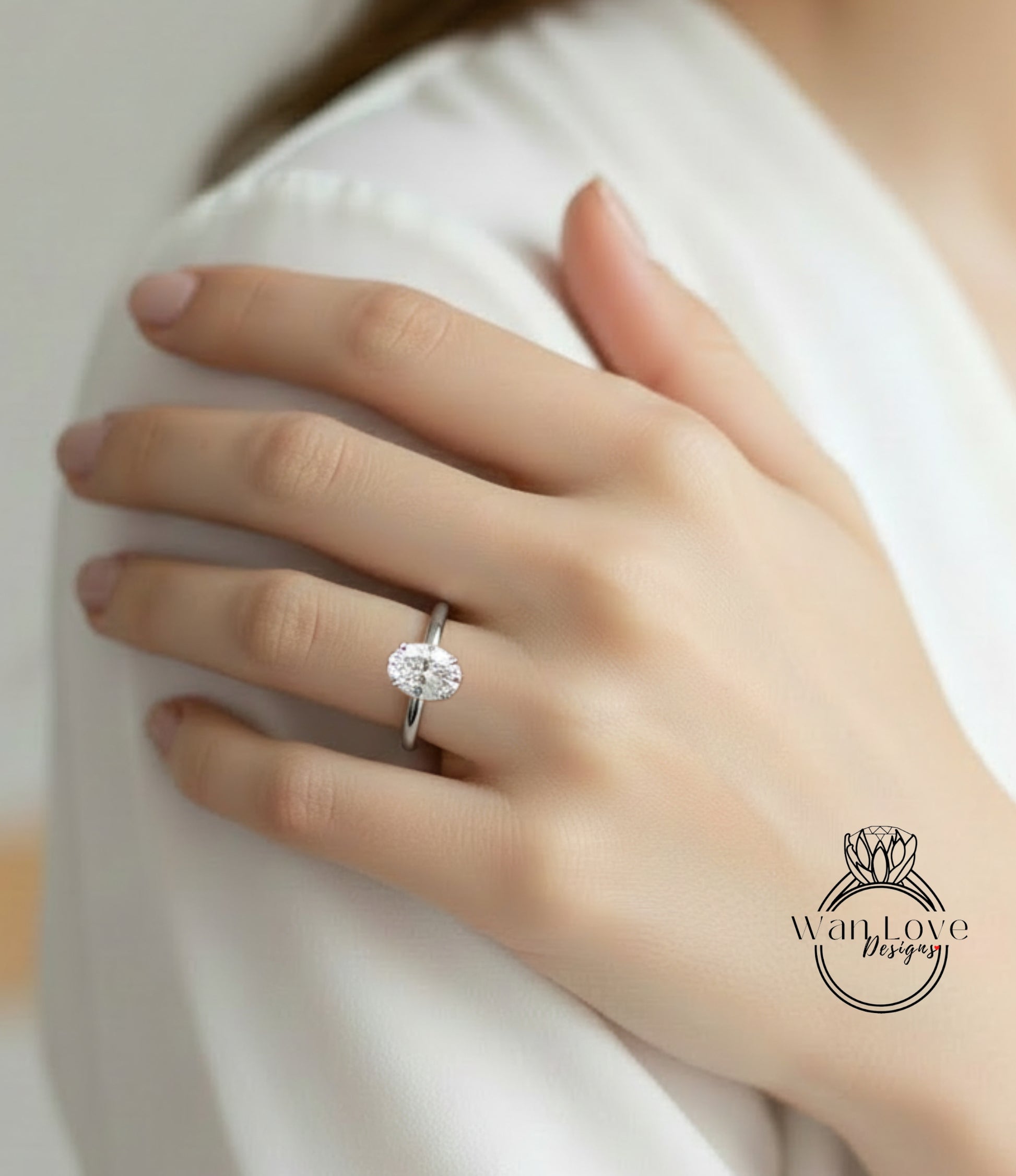 A close-up of a person's hand wearing a diamond engagement ring on the ring finger.