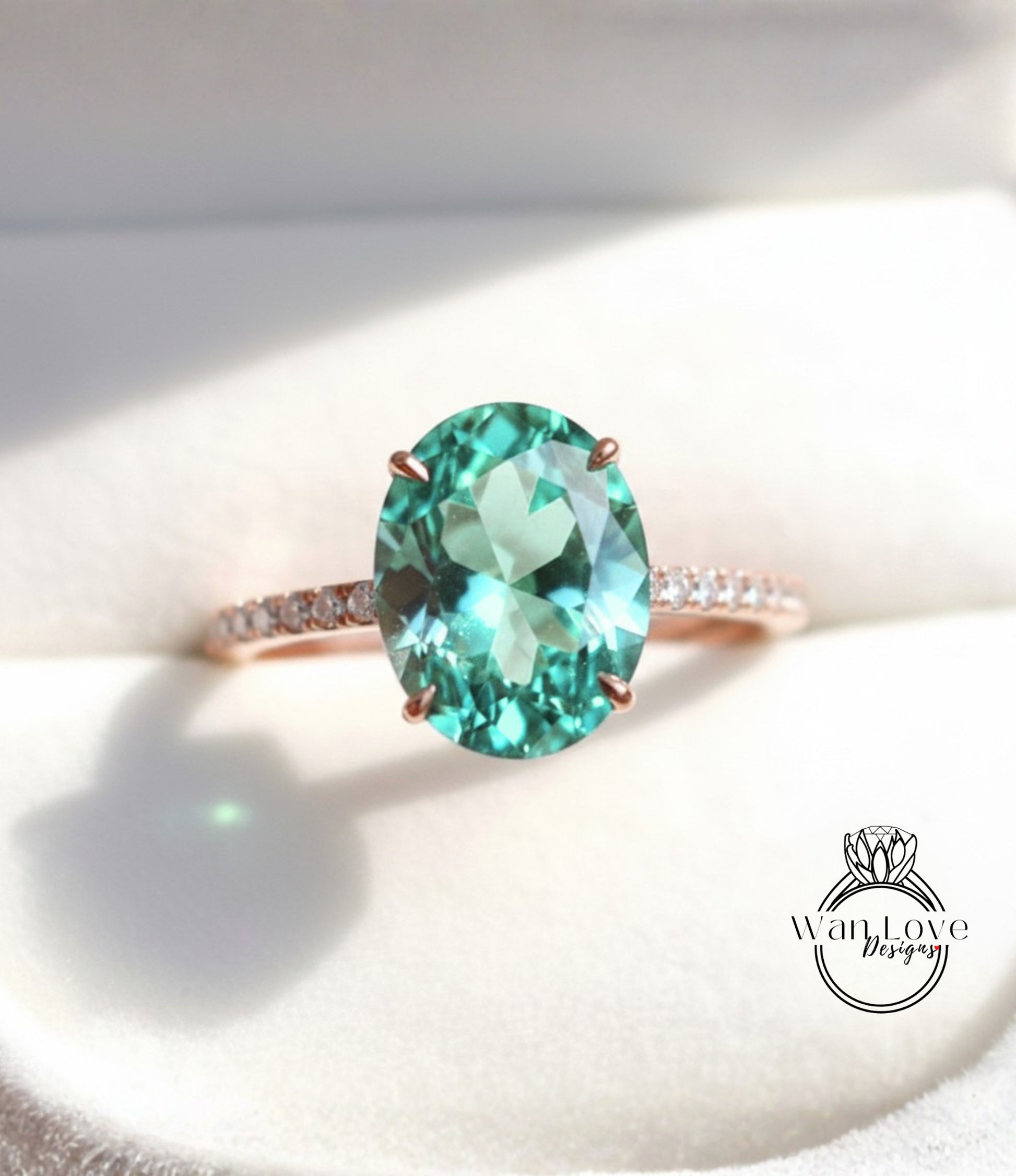 A close-up image of a rose gold ring with a large oval-shaped gemstone, likely a diamond, set in the center of the band.