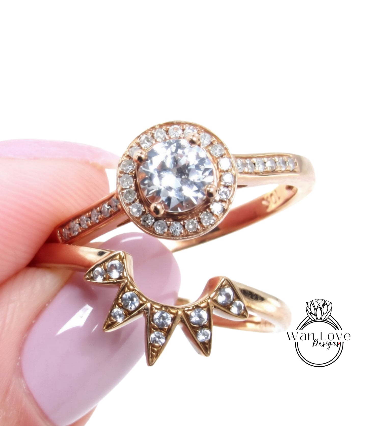 A close-up image of a hand holding a gold ring with a large diamond center stone surrounded by smaller diamonds, and a smaller ring with a star-shaped gemstone on the side.
