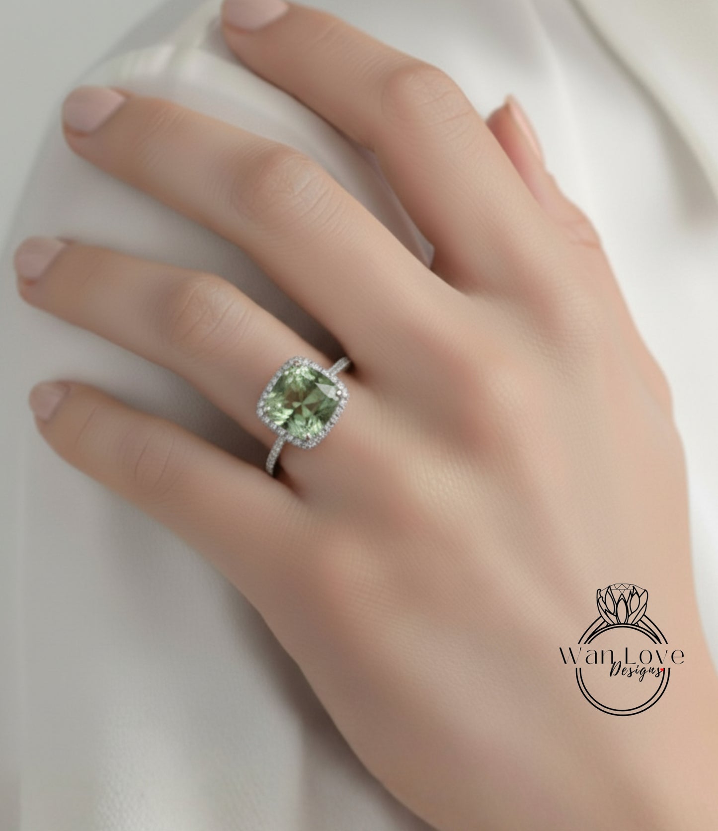 A close-up of a hand wearing a diamond ring with a large, green gemstone.