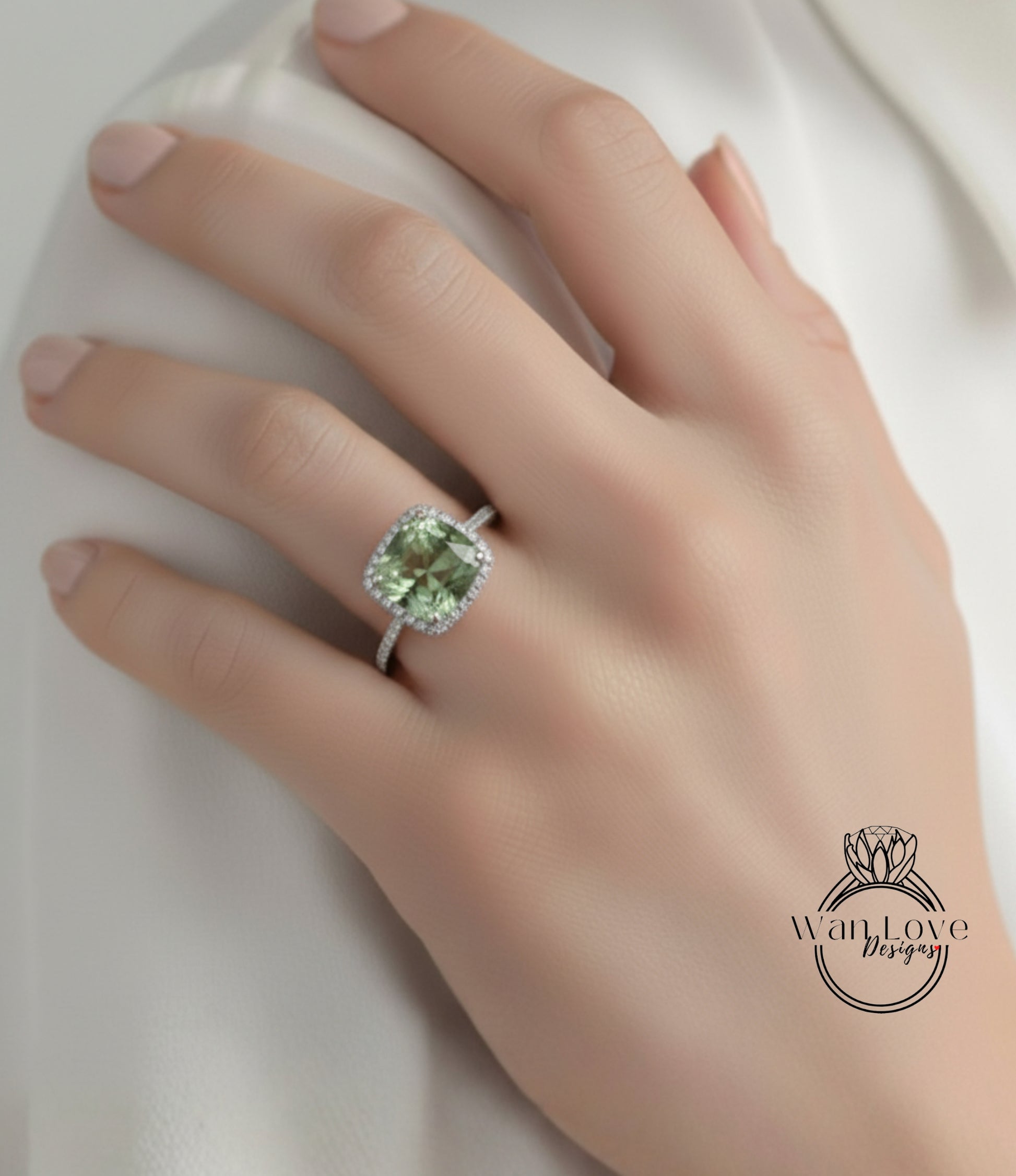 A close-up of a hand wearing a diamond ring with a large, green gemstone.