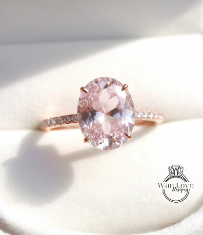 A close-up image of a pink gemstone ring with a large oval-shaped gemstone set in a rose gold band.