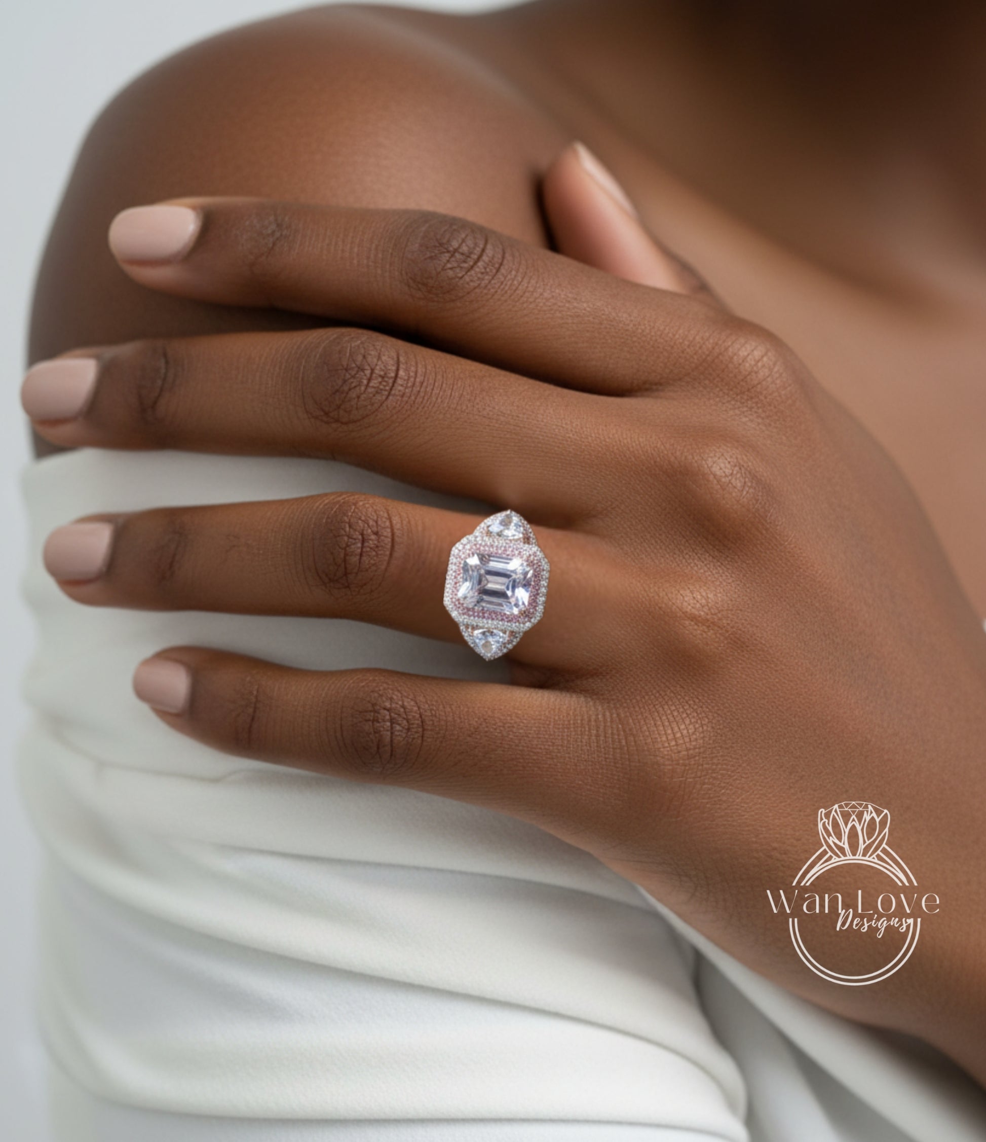 A close-up of a person's hand wearing a large, ornate diamond ring on the ring finger.