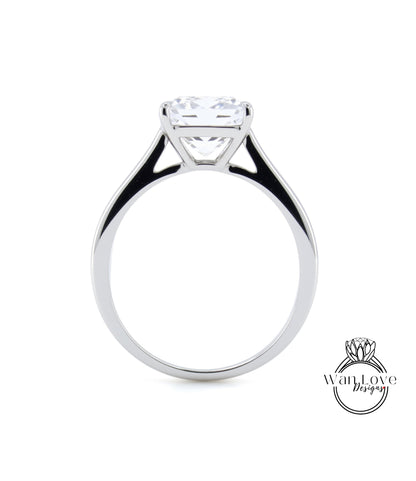 A silver engagement ring with a large, clear gemstone set in the center of the band.