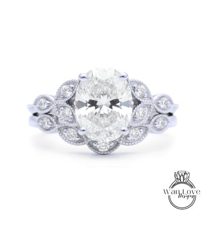 A close-up of a diamond engagement ring with a large oval-shaped diamond surrounded by smaller diamonds and a floral-inspired design.