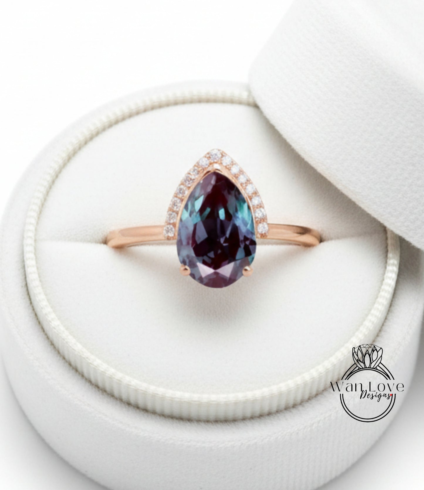 A close-up image of a gold ring with a large, deep purple gemstone set in the center, placed in a white jewelry box.