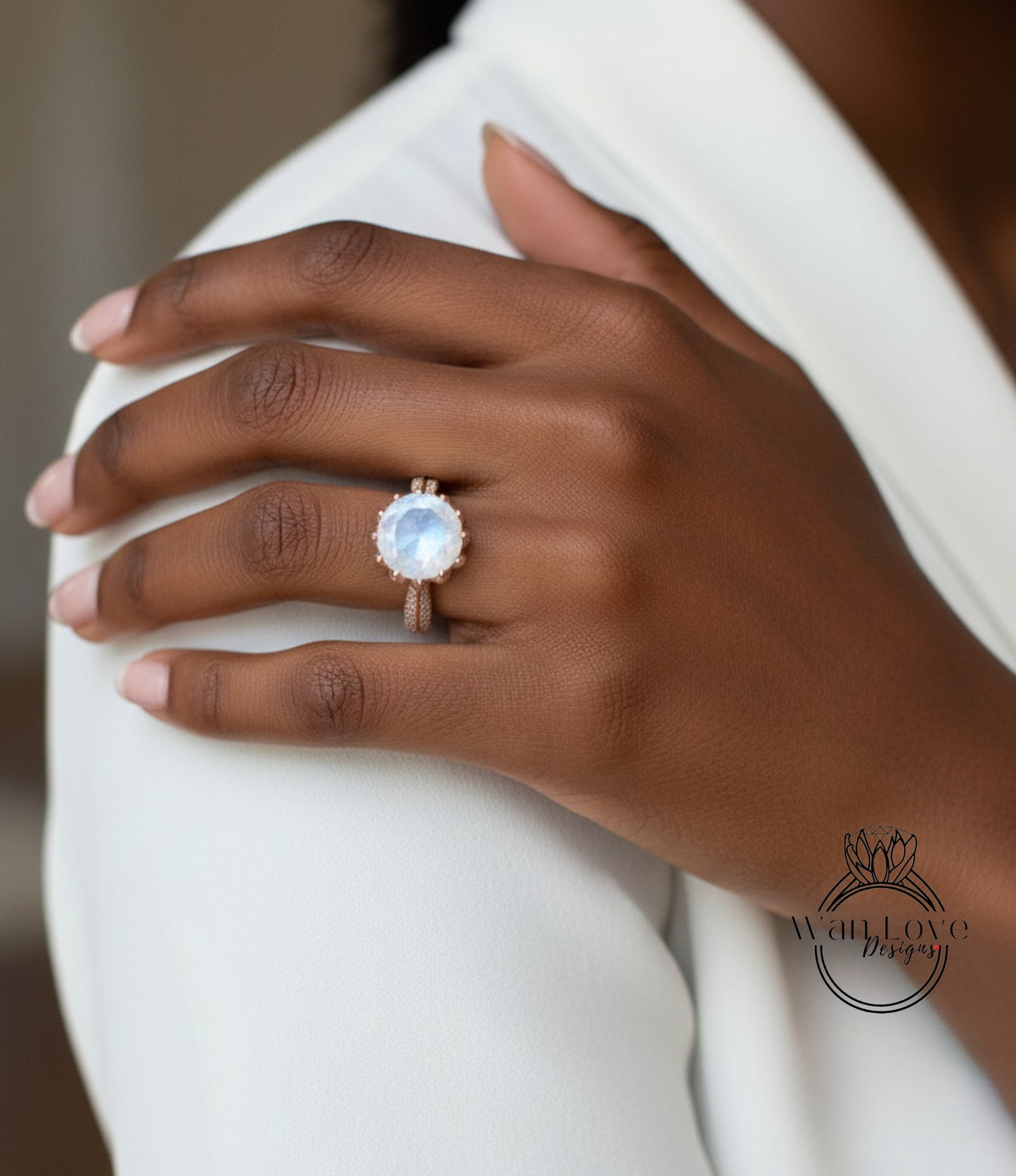A close-up of a person's hand wearing a large, round, blue gemstone ring on the ring finger.