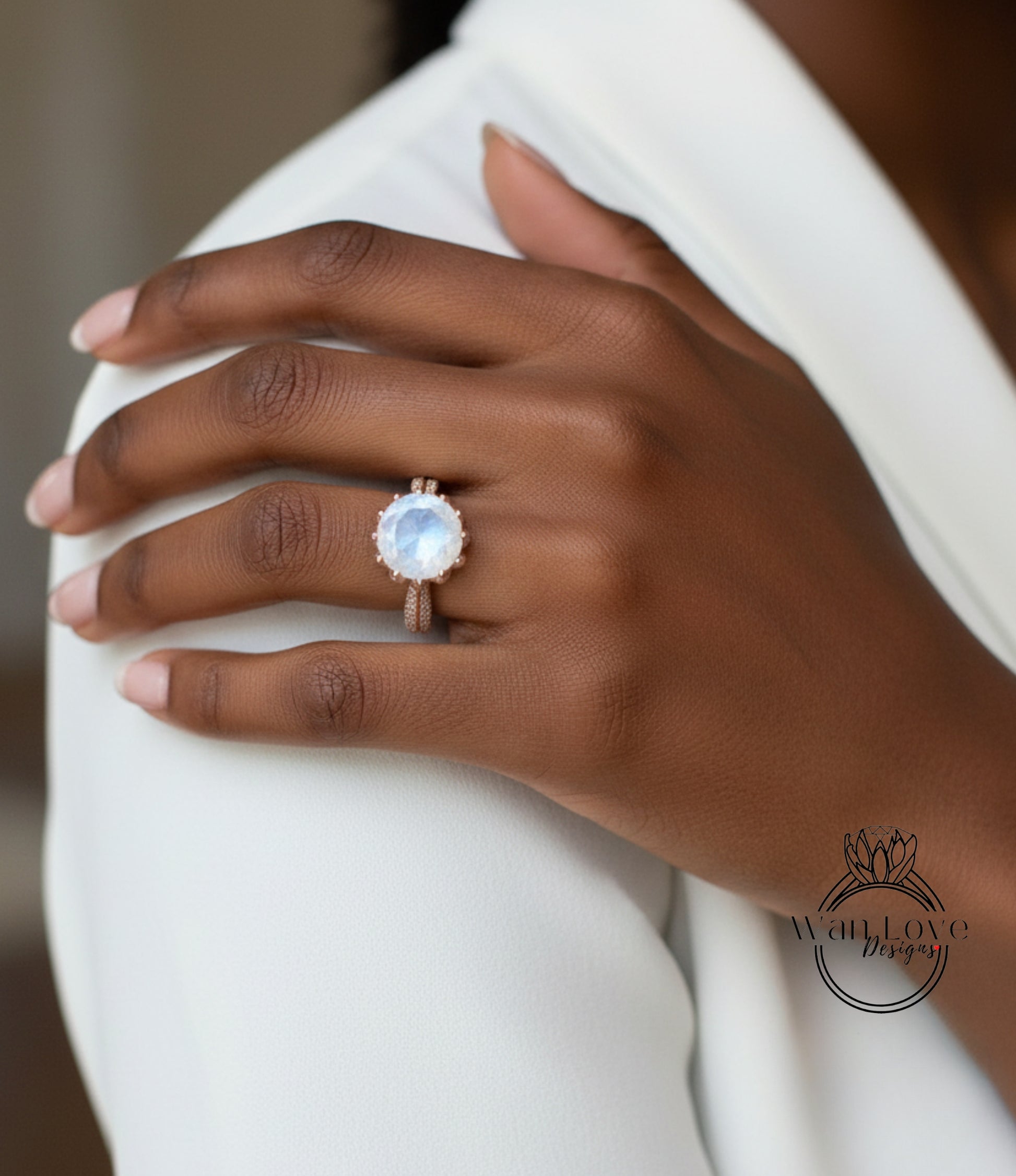 A close-up of a person's hand wearing a large, round, blue gemstone ring on the ring finger.