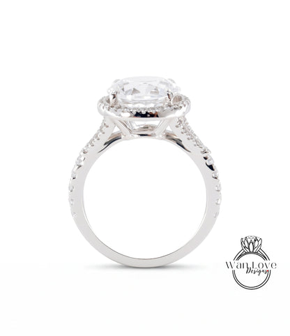 A close-up view of a silver engagement ring with a large central diamond and a halo of smaller diamonds around it.
