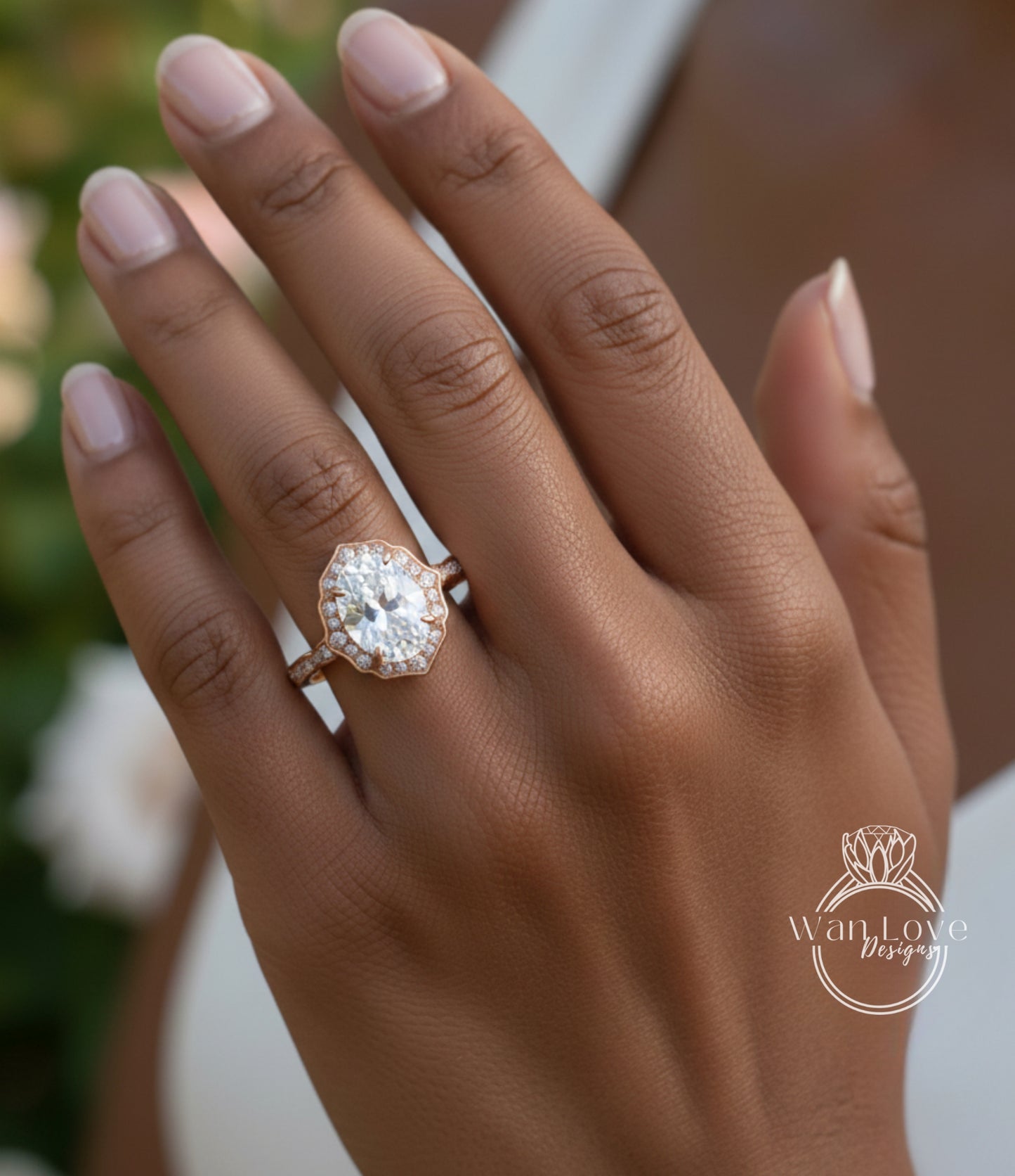 A close-up of a person's hand wearing a large, oval-shaped diamond engagement ring with a halo of smaller diamonds around the center stone.