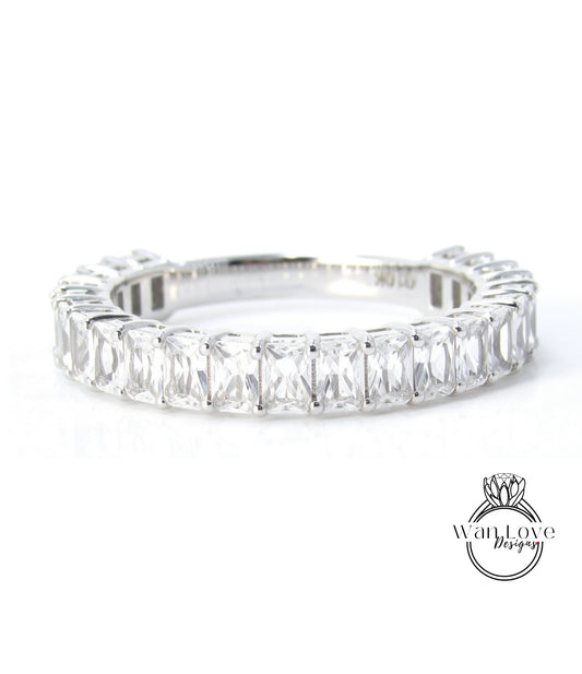 A silver ring with a row of clear gemstones, likely diamonds, set in a band.