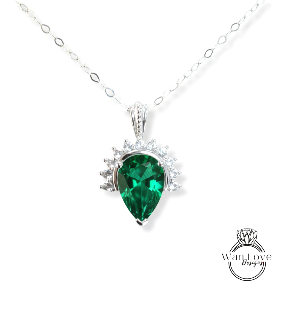 A silver necklace with a large, green gemstone pendant.
