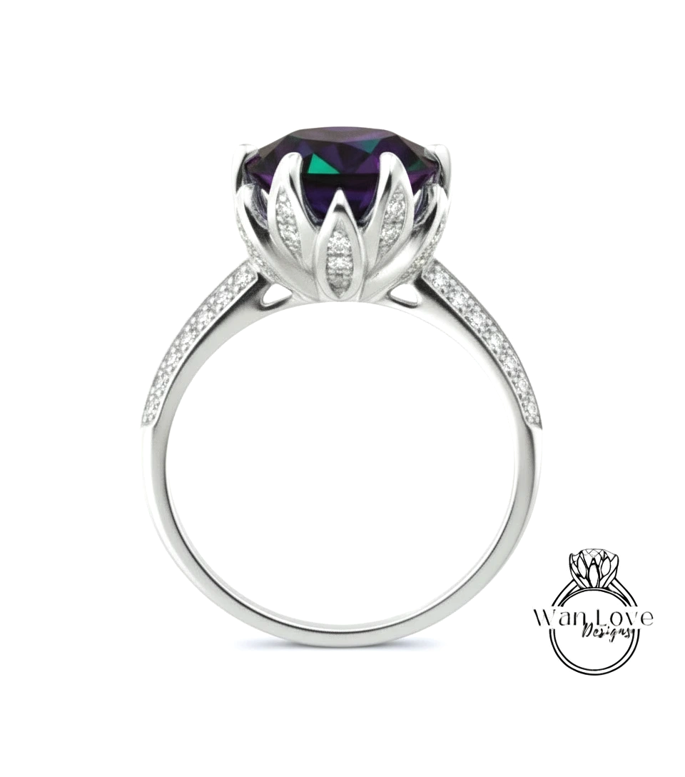 A silver ring with a large purple gemstone, likely a diamond, set in a flower-like design.