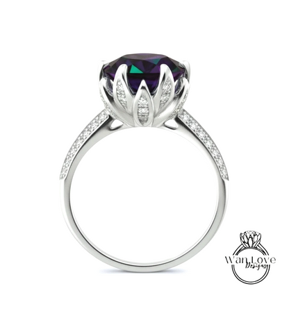 A silver ring with a large purple gemstone, likely a diamond, set in a flower-like design.