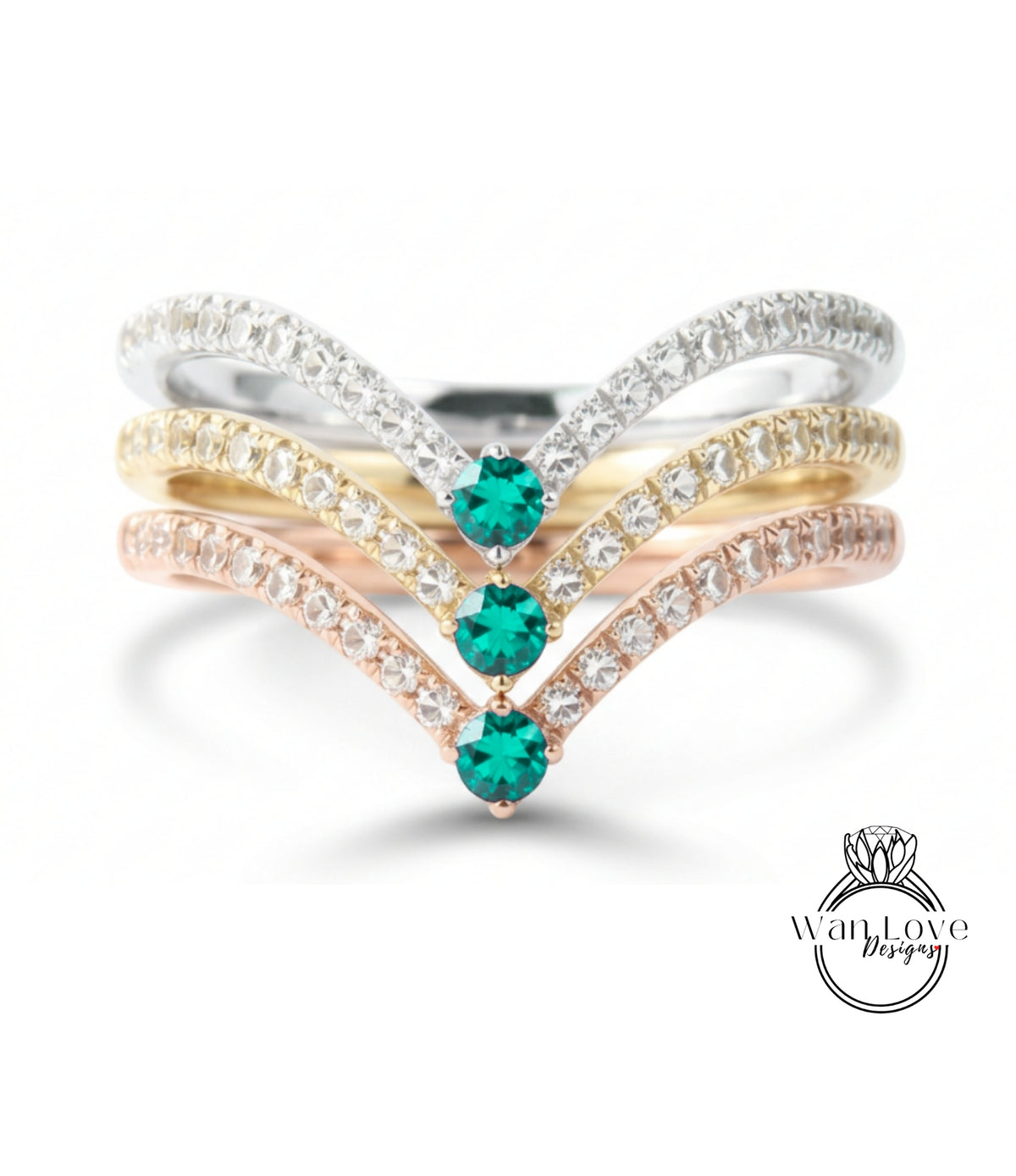 A ring with a diamond band and three green gemstones set in it.