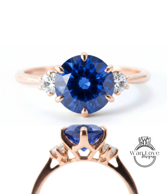 a beautiful blue sapphire engagement ring with a rose gold band and three diamonds.
