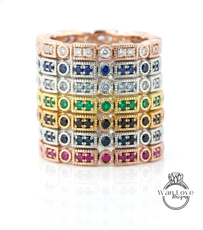 A stack of rings with various colored gemstones, including diamonds, arranged in a circular pattern.