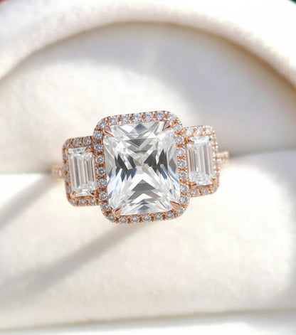 A close-up image of a beautiful engagement ring with a large central diamond surrounded by smaller diamonds on either side.