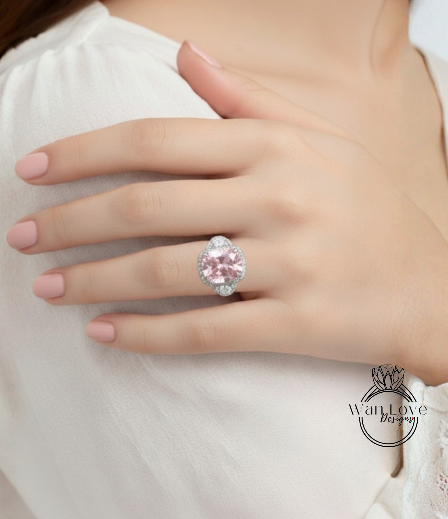 A close-up of a person's hand wearing a large, pink gemstone ring on the ring finger.