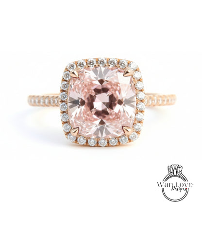 A stunning engagement ring with a large, pink gemstone set in a halo of smaller diamonds, surrounded by a delicate gold band.