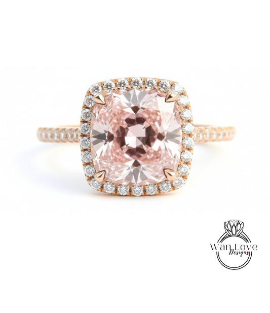A stunning engagement ring with a large, pink gemstone set in a halo of smaller diamonds, surrounded by a delicate gold band.