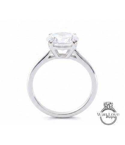 A silver engagement ring with a large, clear gemstone set in the center of the band.