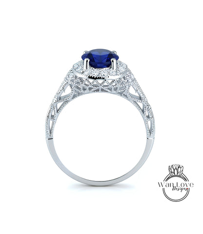 A silver ring with a large blue gemstone, possibly a sapphire, set in an intricate, ornate design.