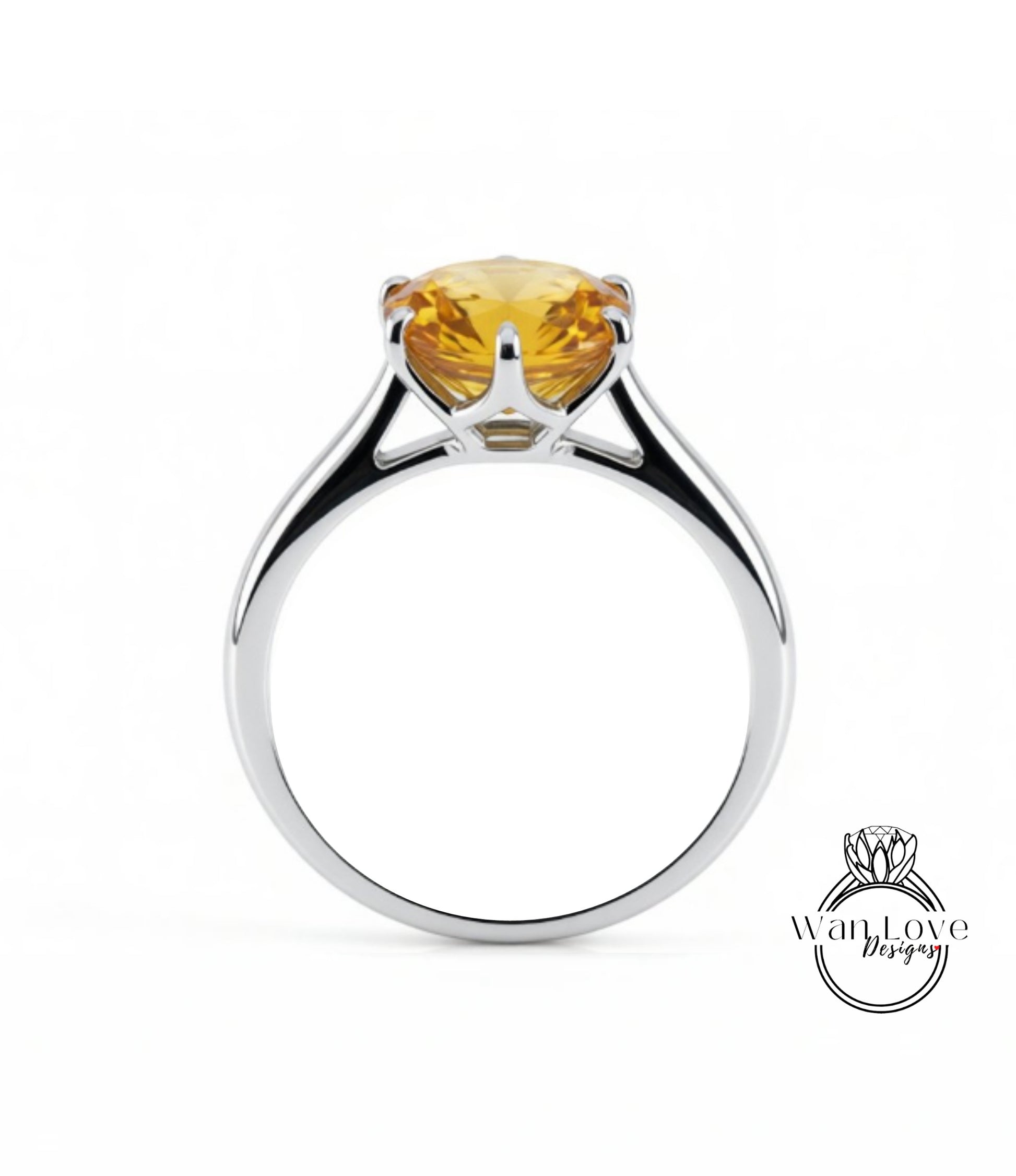 A silver ring with a large yellow gemstone, likely a diamond, set in the center.
